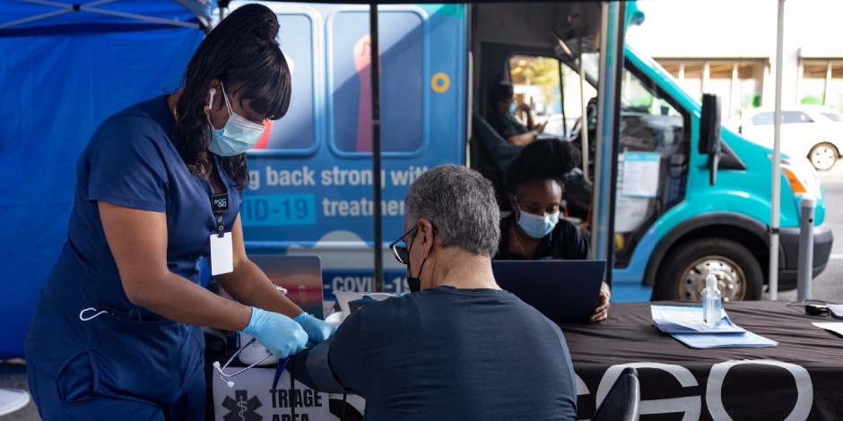 nurse taking vitals of a patient at an outdoor COVID 19 testing site 